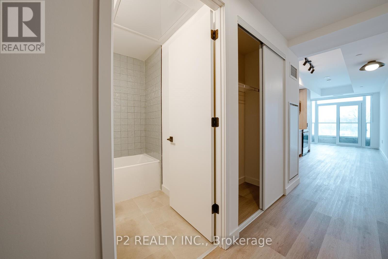 A bathroom with a white tub and a white door.