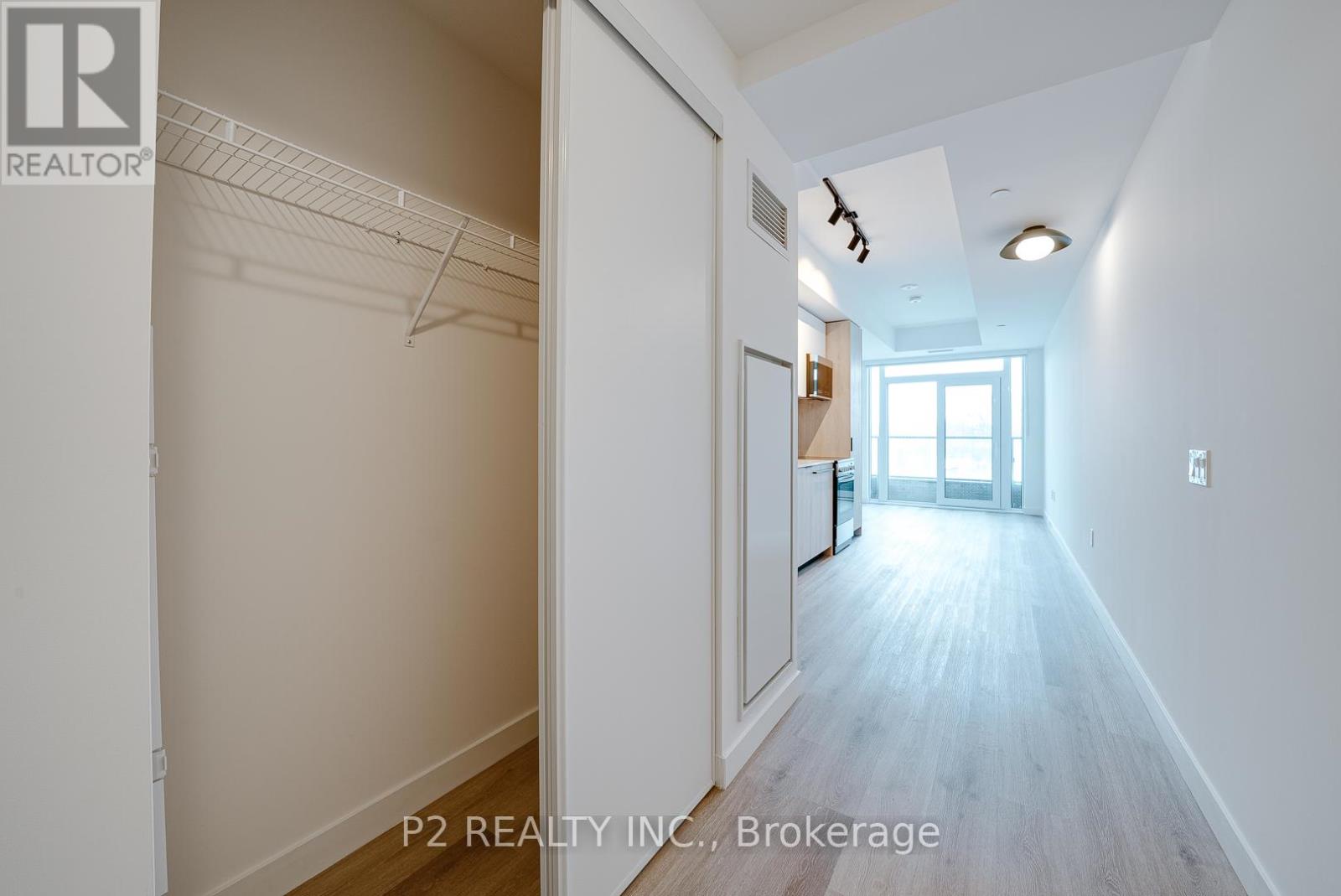 A hallway with a door on the right and a window in the distance.