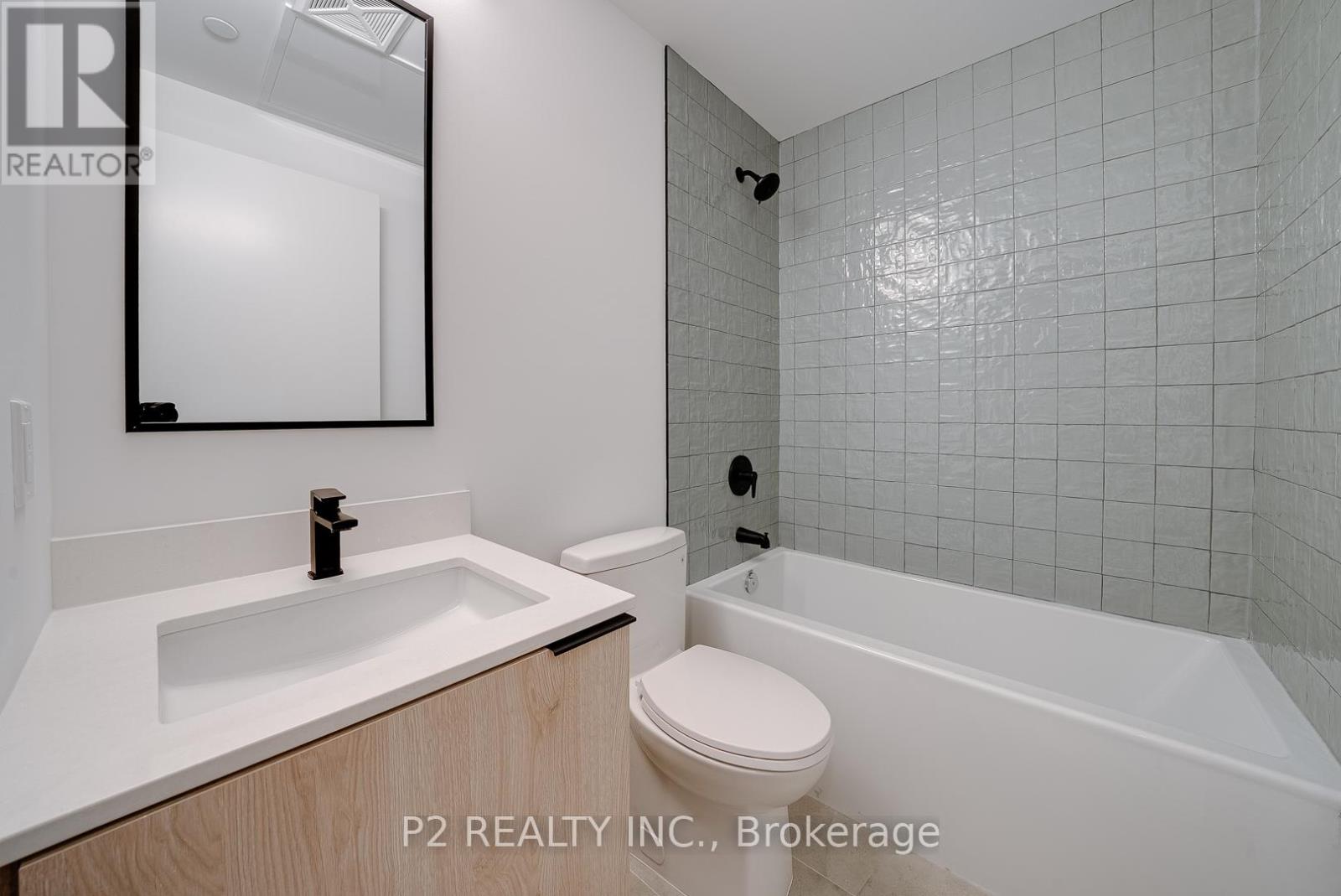 A bathroom with a white sink, toilet, and bathtub.