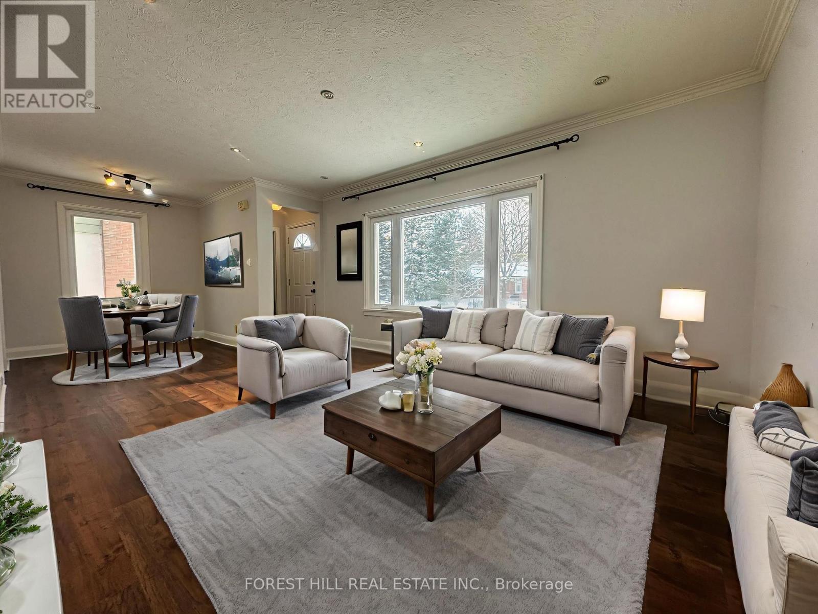 A living room with a grey sofa, a wooden coffee table, and a grey rug.