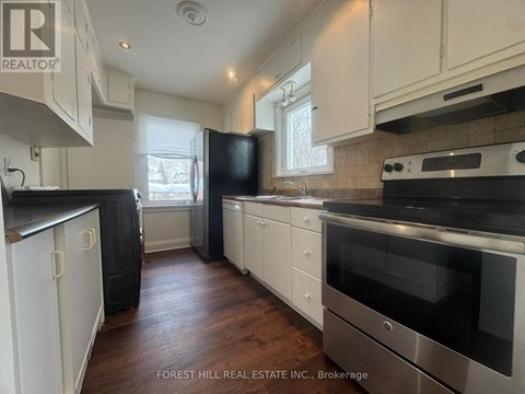 A kitchen with white cabinets and black appliances.