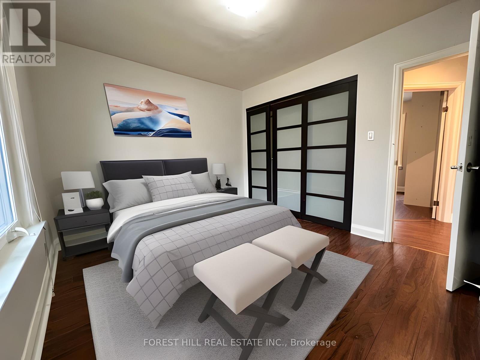 A bedroom with a large bed and a painting on the wall.