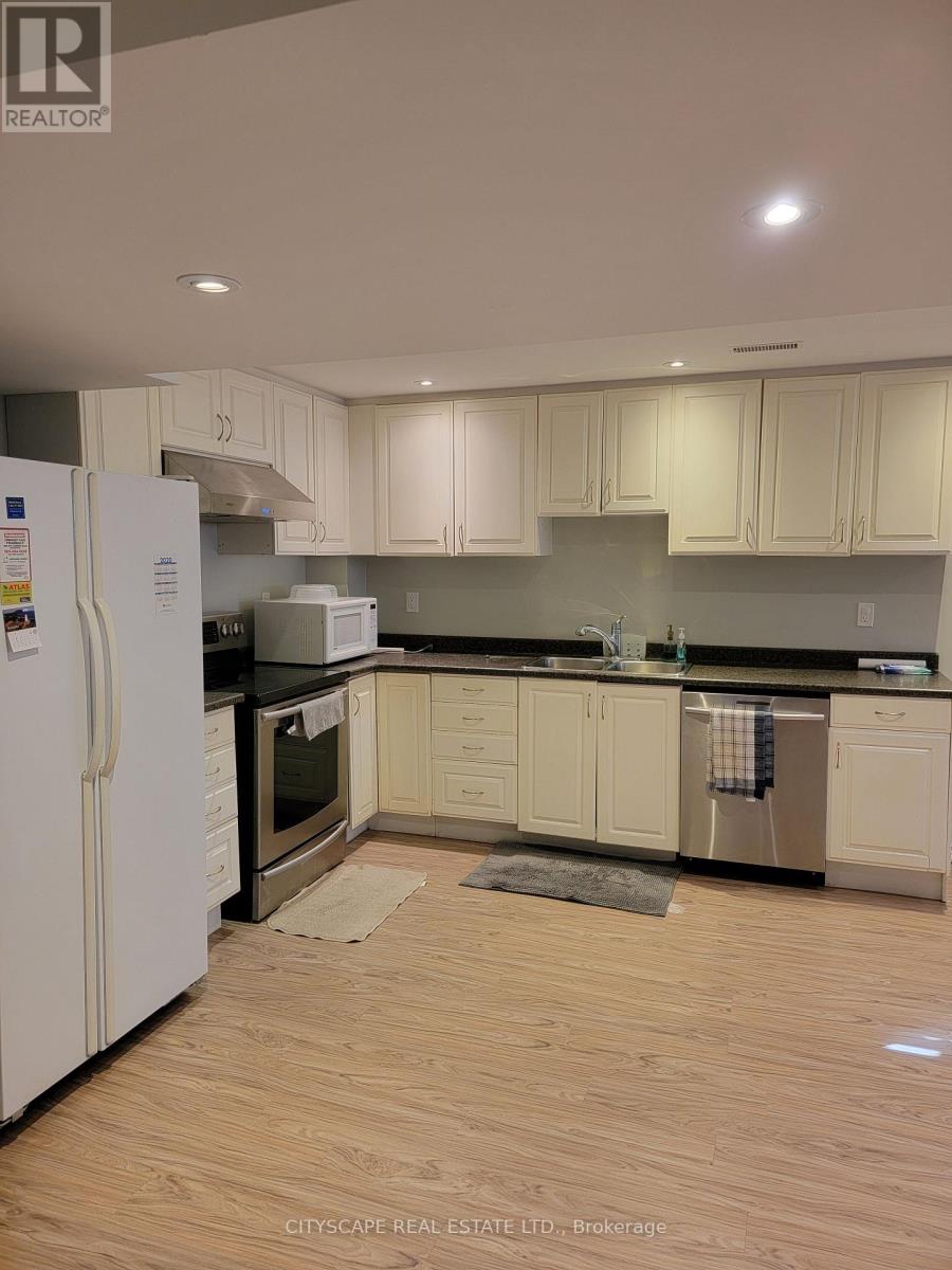 A kitchen with white cabinets and a white refrigerator.