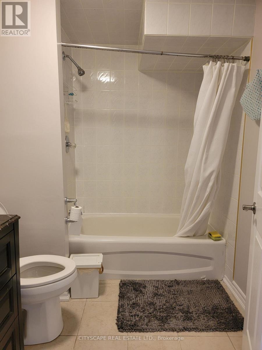 A white bathroom with a toilet, tub, and shower.