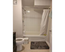 A white bathroom with a toilet, tub, and shower.