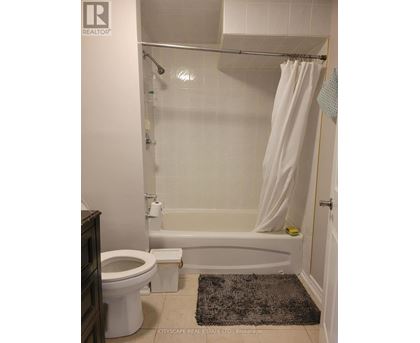 A white bathroom with a toilet, tub, and shower.