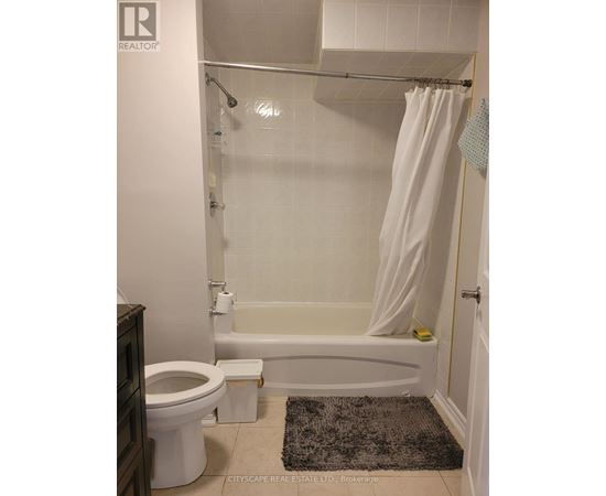 A white bathroom with a toilet, tub, and shower.