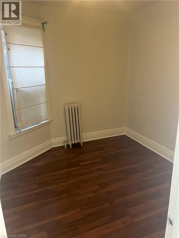 A room with wooden floors and a window with blinds.