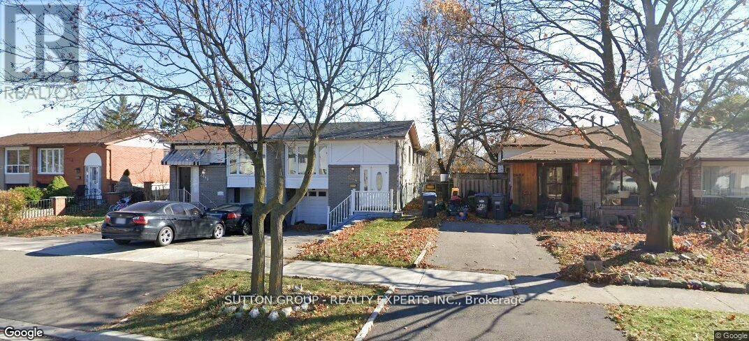 A street view of a residential area with houses and parked cars.