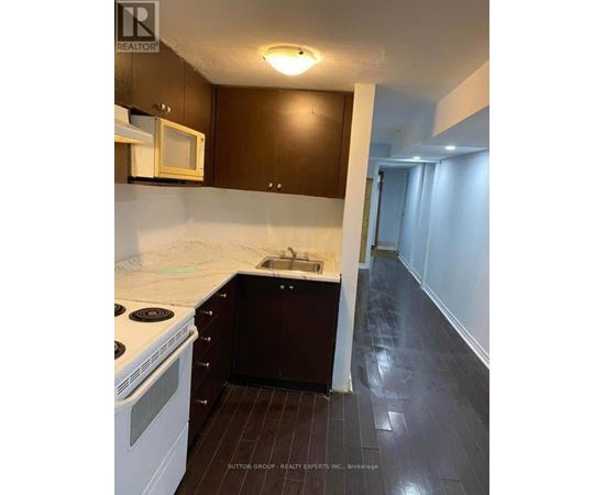 A kitchen with dark wood cabinets and white appliances.
