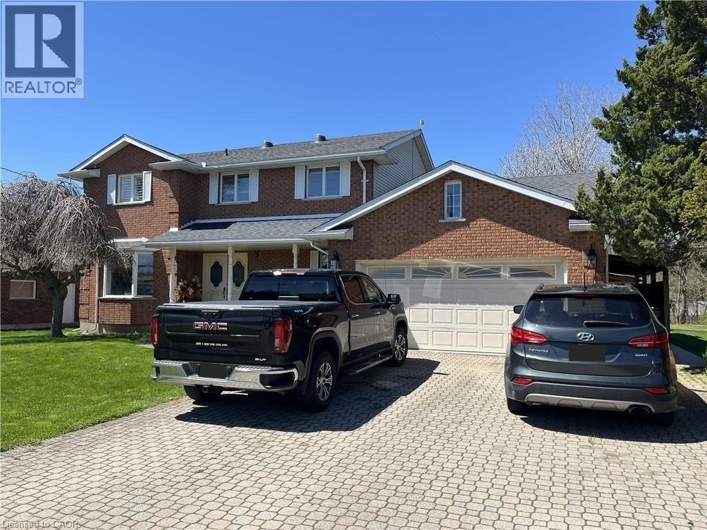 A house with a black truck and grey car in front.