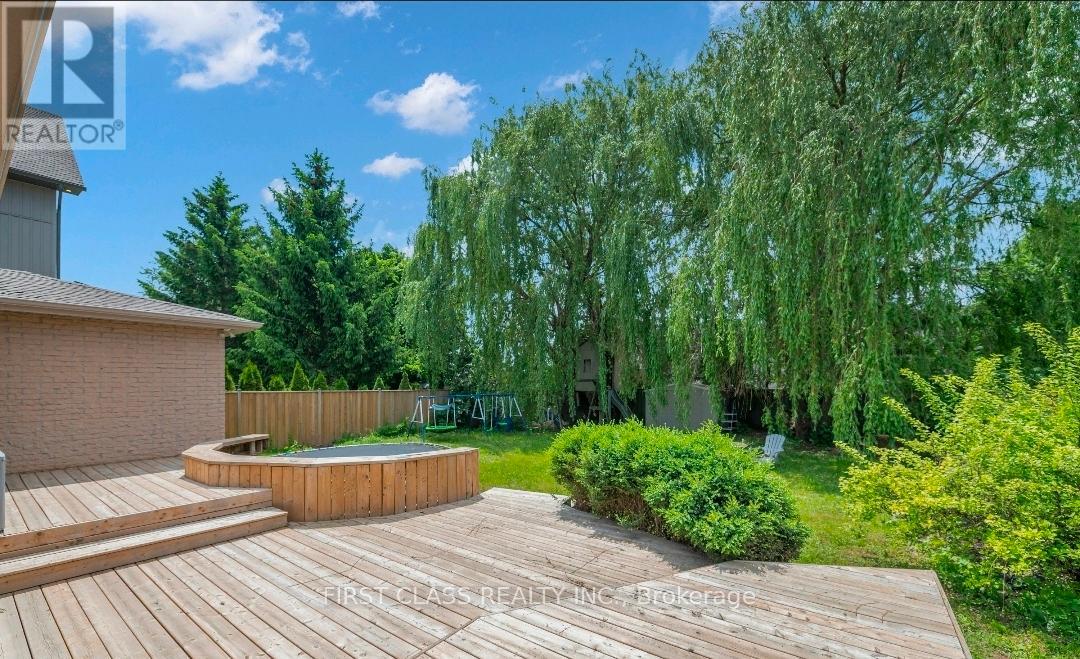 A backyard with a wooden deck and a hot tub.