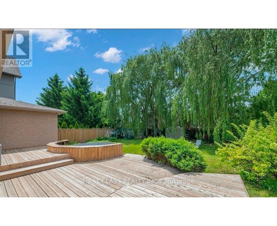 A backyard with a wooden deck and a hot tub.
