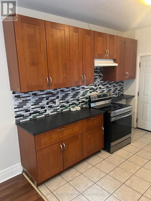 A kitchen with wooden cabinets and a black counter top.