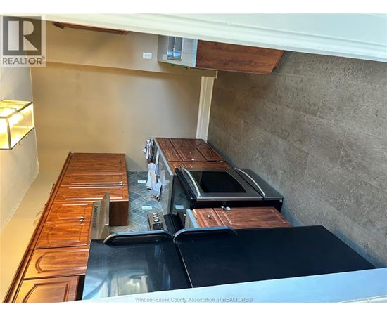 A kitchen with a stainless steel refrigerator and wooden cabinets.