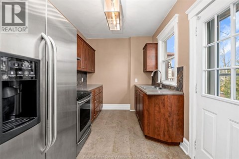A kitchen with a stainless steel refrigerator and wooden cabinets.