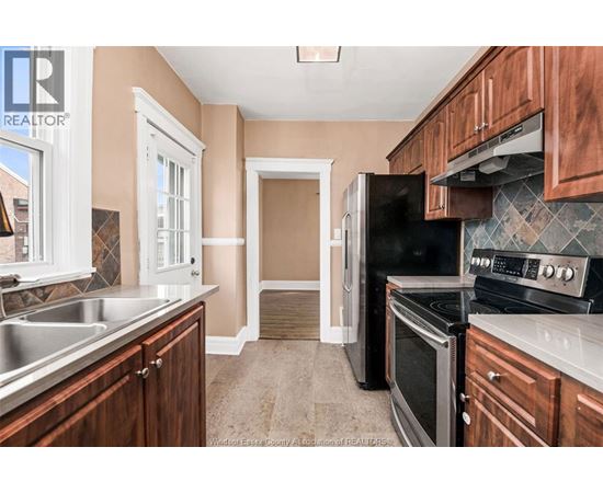 A kitchen with wooden cabinets and a black refrigerator.