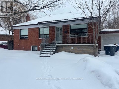 A house with a red brick exterior and a white roof is surrounded by snow.