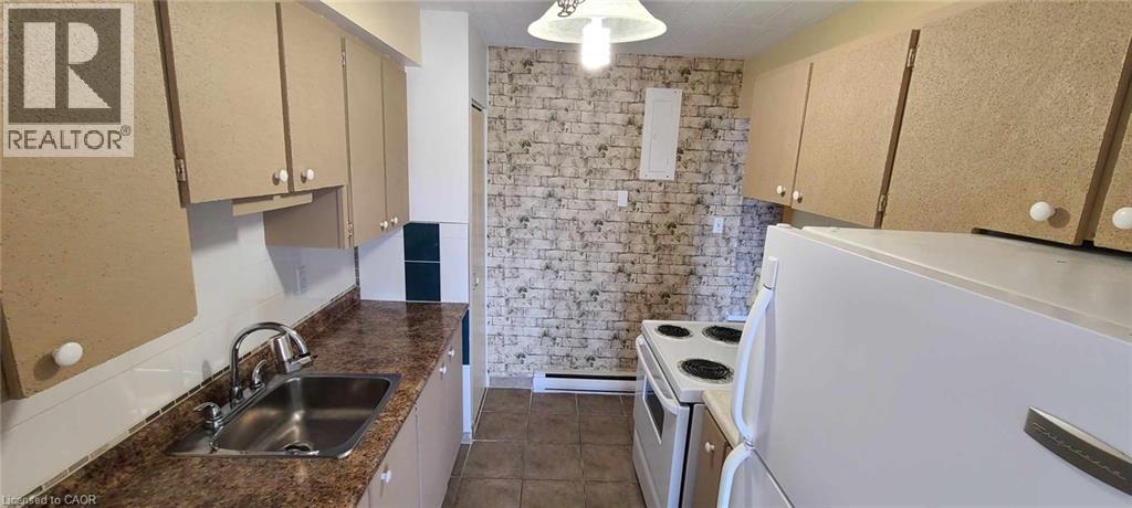 A kitchen with a sink, stove, and cabinets.
