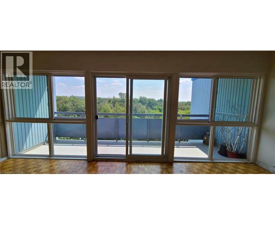 A balcony with a view of a forest and a fence.