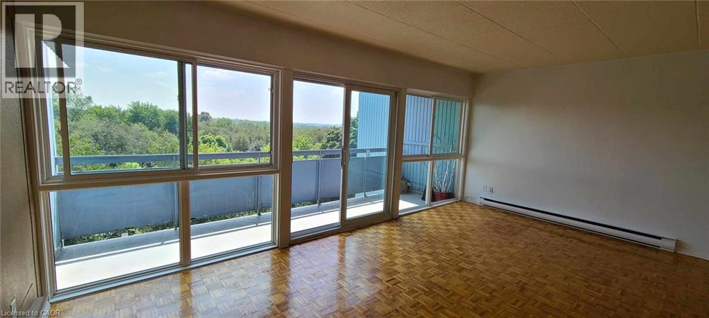 A large empty room with a view of trees through the windows.