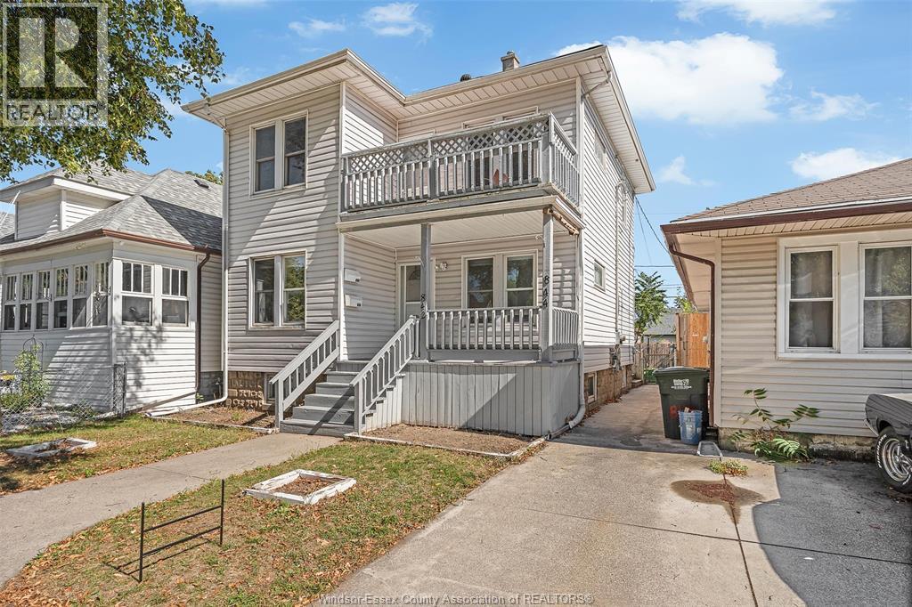 A two-story house with a balcony on the second floor.