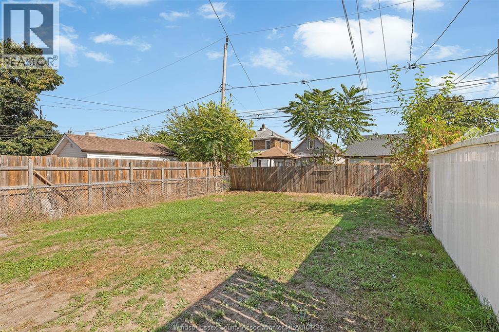 A backyard with a wooden fence and a grassy area.