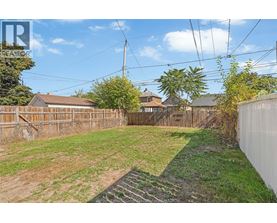 A backyard with a wooden fence and a grassy area.