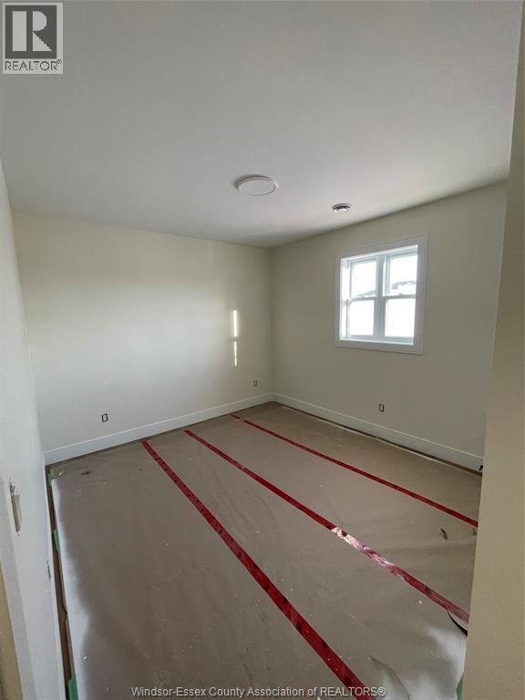 A room with a window and a floor covered in red tape.