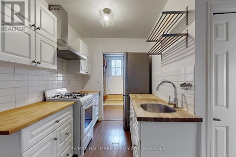 A kitchen with white cabinets and a wooden counter top.