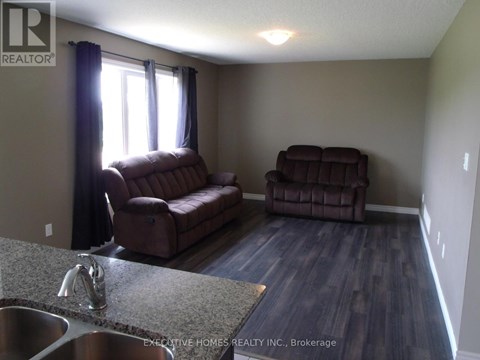 A living room with a brown couch and a brown chair.