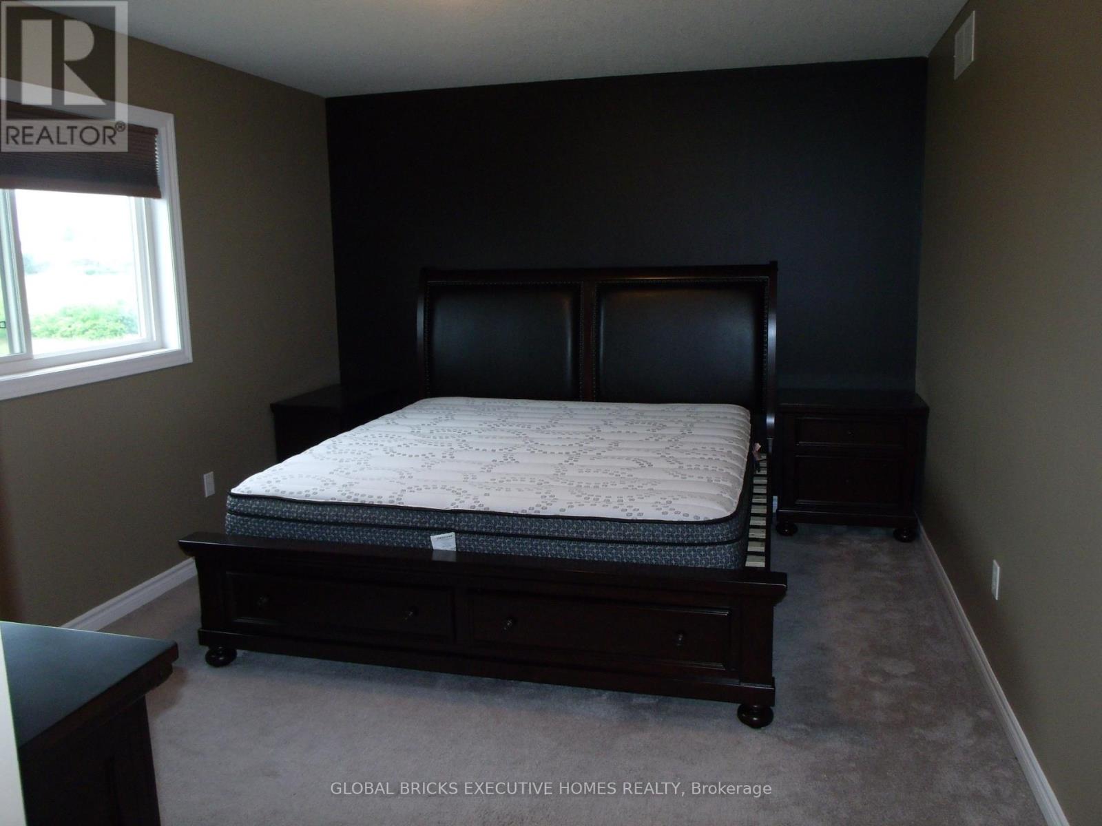 A bedroom with a large bed and a window.