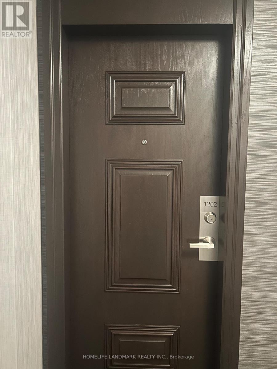 A brown door with a silver handle and a number 1202 on the right side.