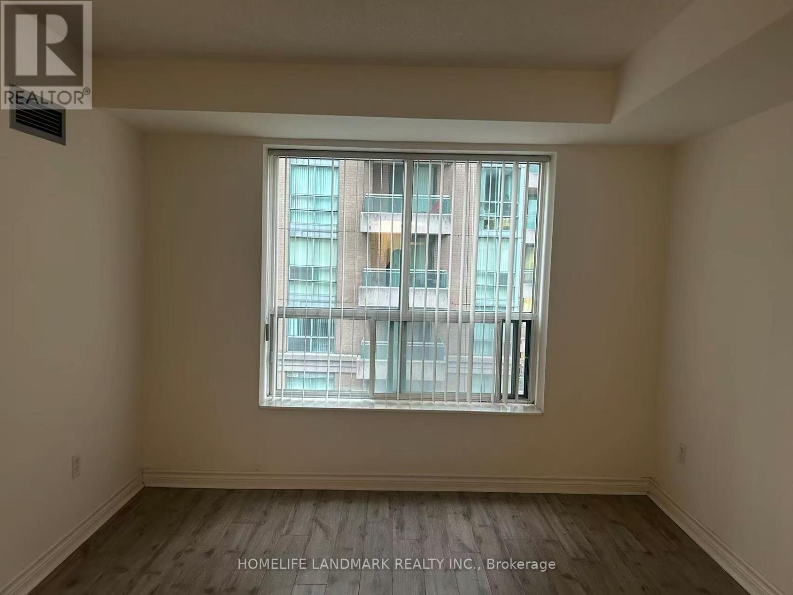 A room with a large window and wooden flooring.