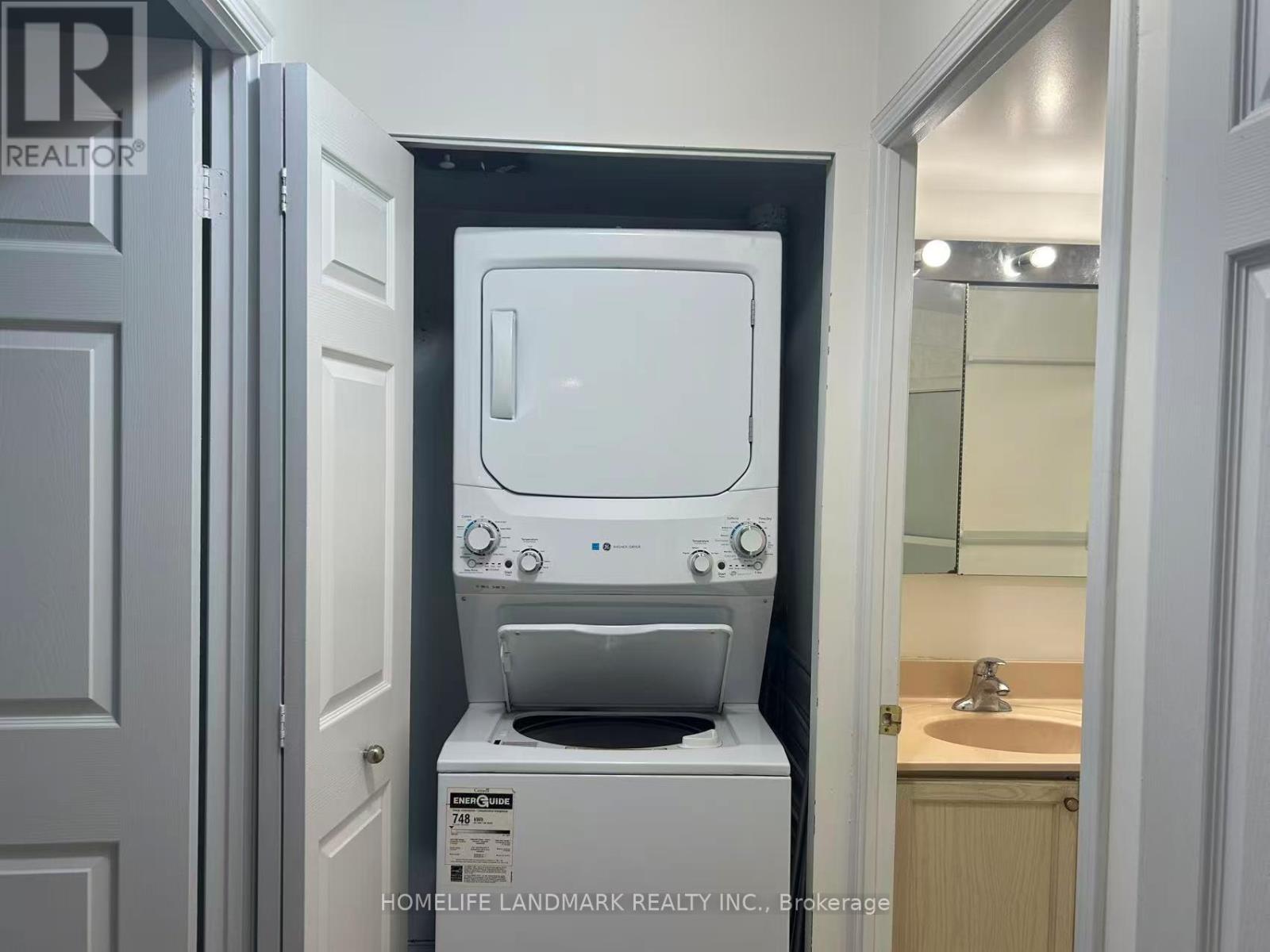 A small white washing machine is in a small bathroom.