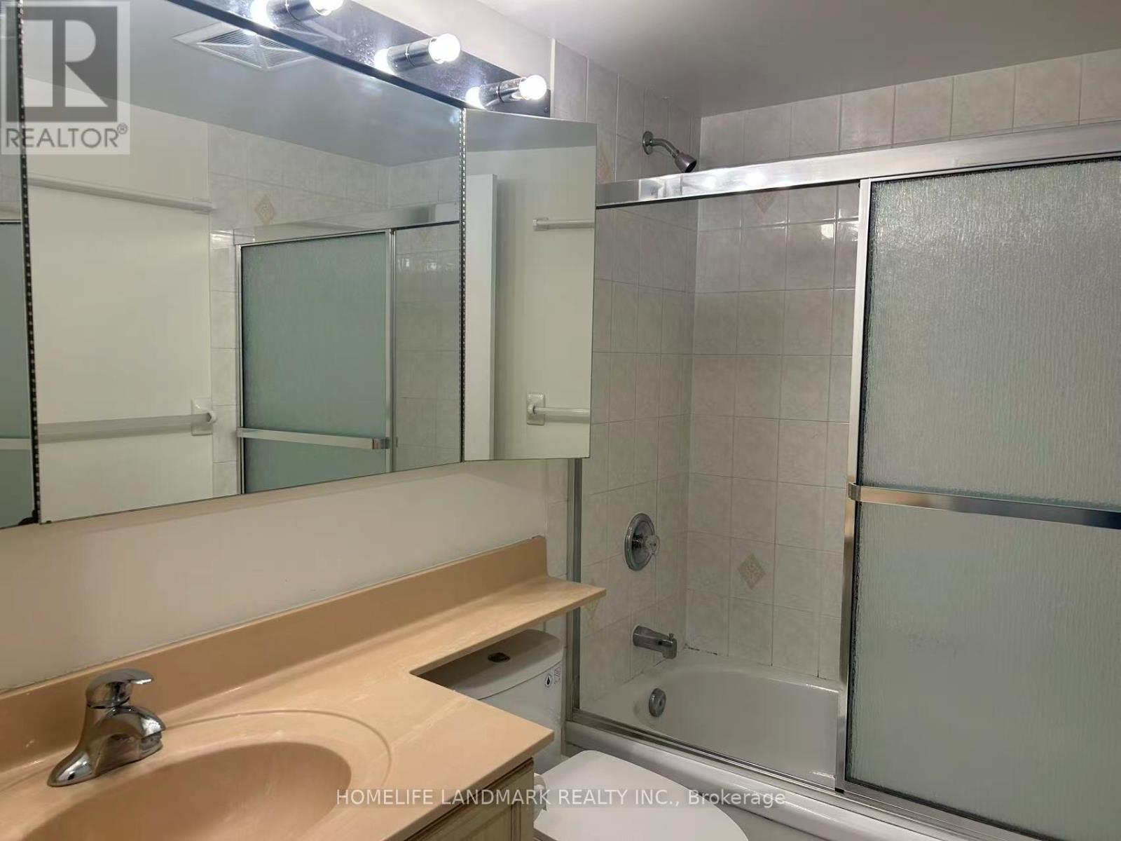 A bathroom with a sink, mirror, and shower.