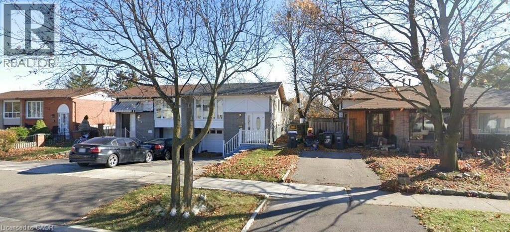 A residential street with houses and parked cars.