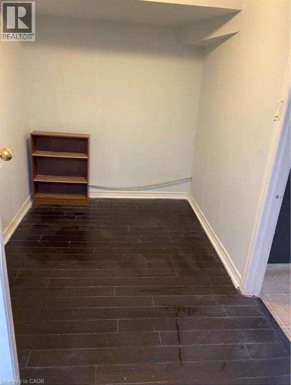 A room with a wooden floor and a shelf against the wall.
