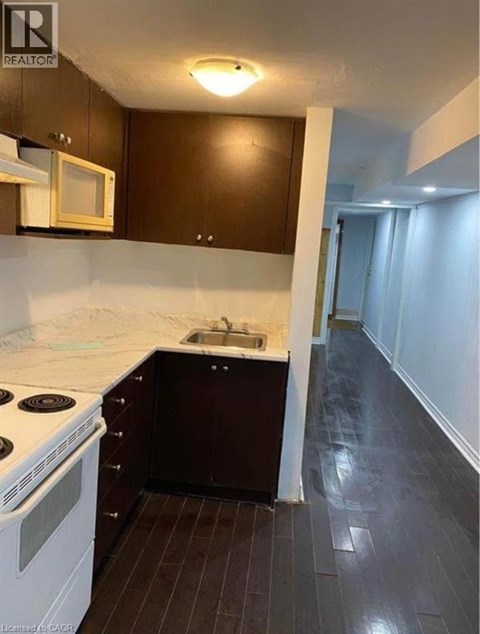 A kitchen with dark wood cabinets and white appliances.