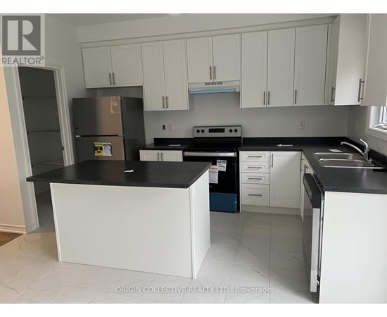 A kitchen with white cabinets and black countertops.
