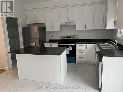 A kitchen with white cabinets and black countertops.