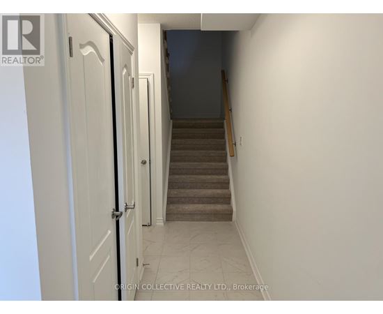 A hallway with a staircase leading to a bedroom.