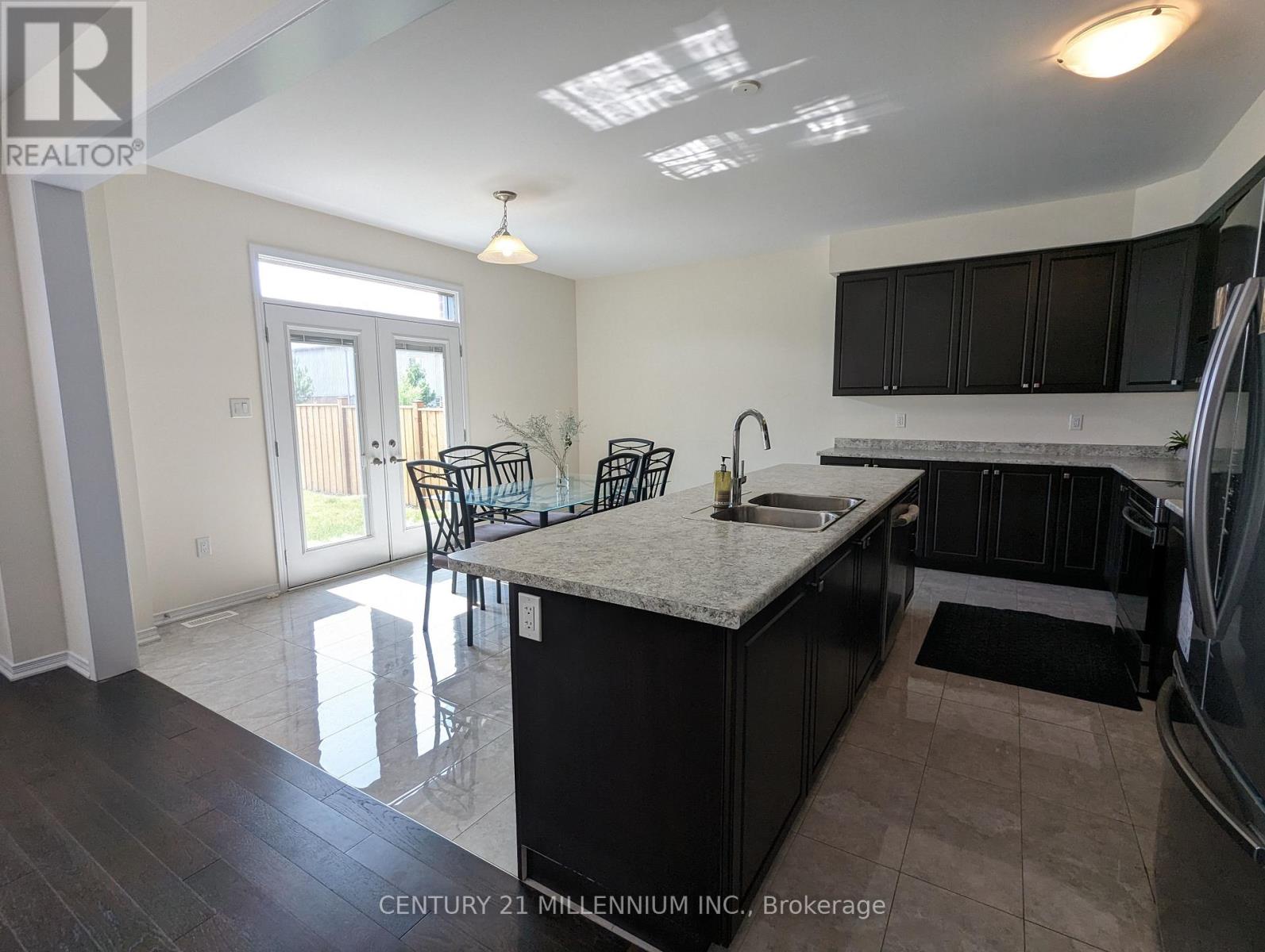 A kitchen with black cabinets and a white countertop.