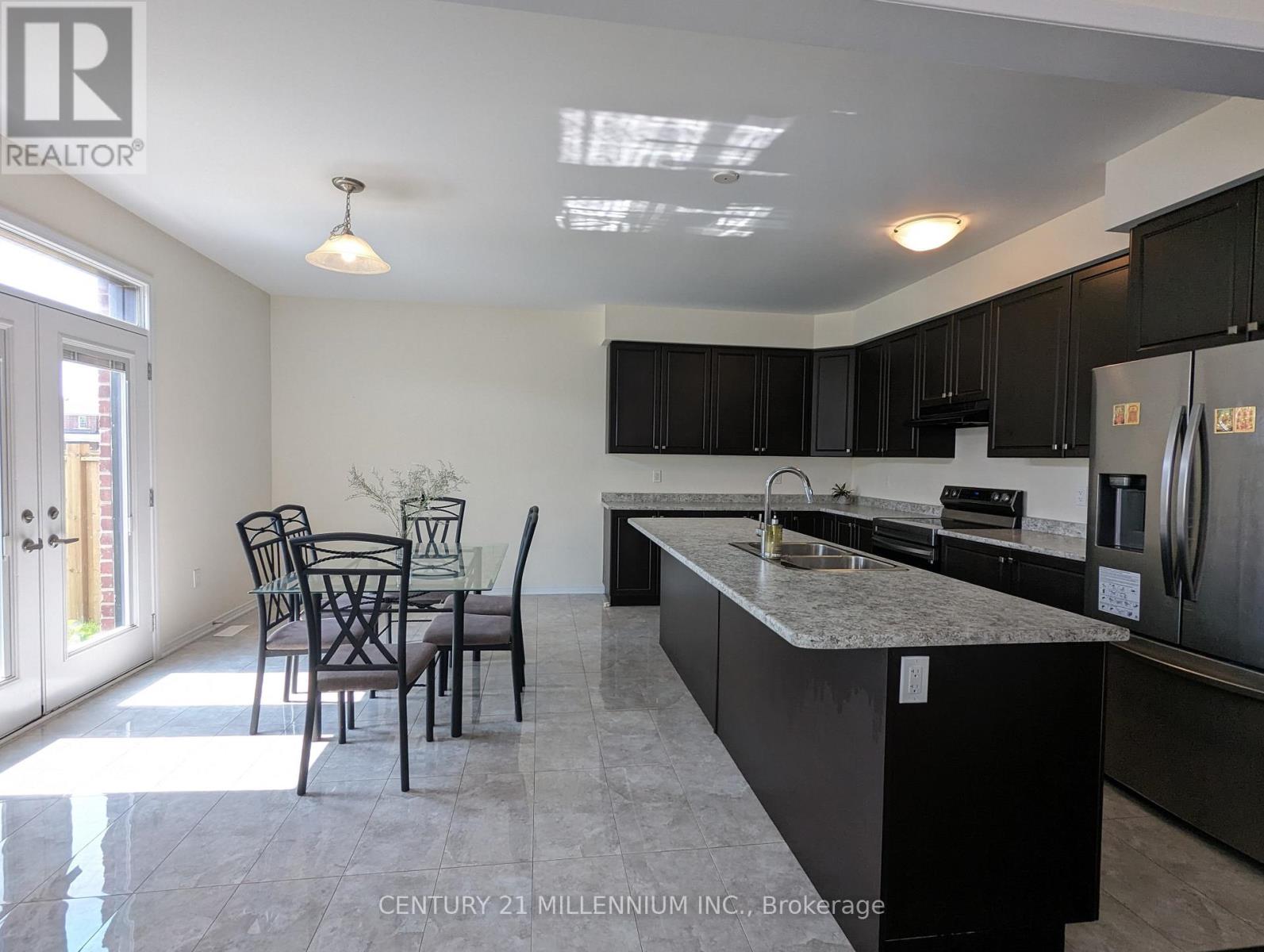 A kitchen with black cabinets and a marble countertop.