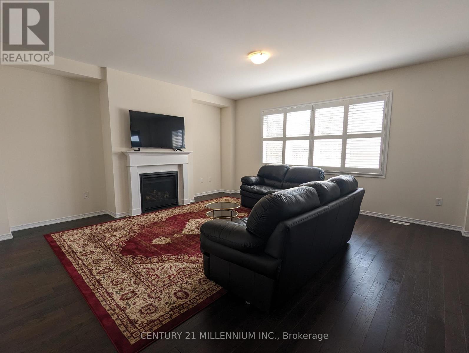 A living room with a fireplace and a TV on the wall.