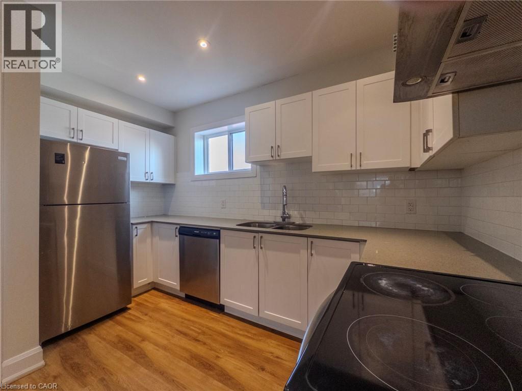 A kitchen with white cabinets and a stainless steel refrigerator.