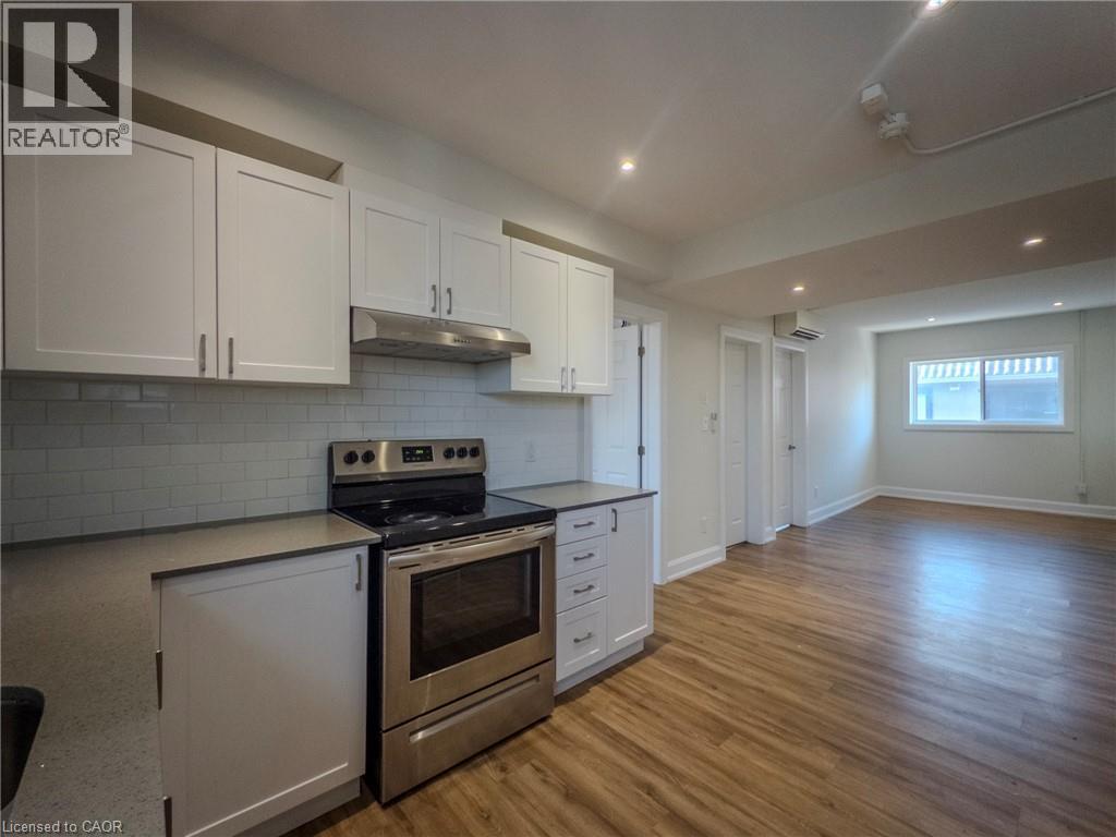 A kitchen with white cabinets and a stainless steel oven.