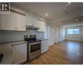 A kitchen with white cabinets and a stainless steel oven.