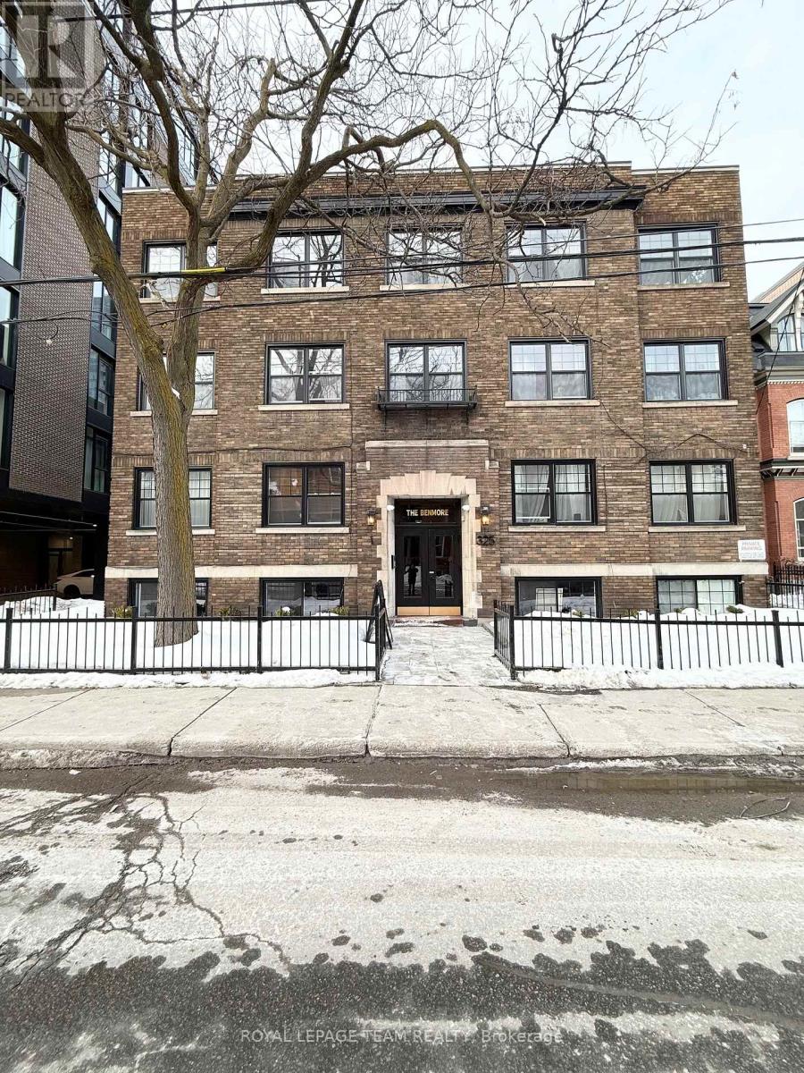 A brick building with a black fence in front.