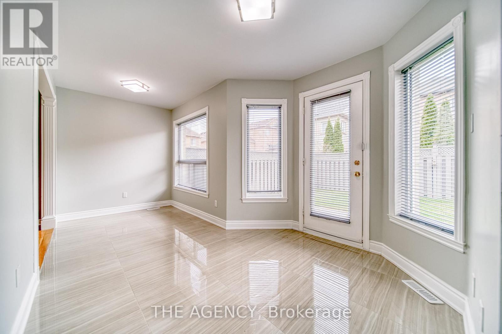 A spacious room with a door, a window, and a wall.